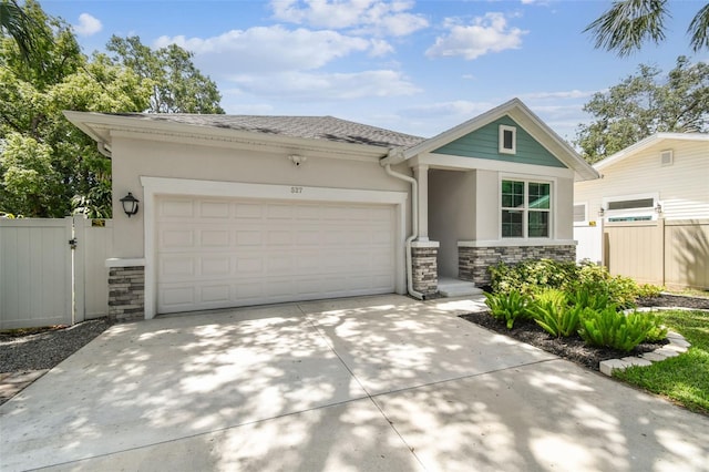 527 Bay St, Dunedin, FL 34698 - view of front facade featuring stone siding, stucco siding, an attached garage, and concrete driveway