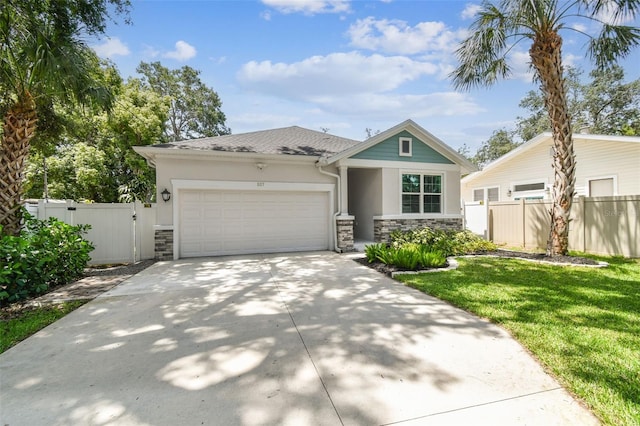 527 Bay St, Dunedin, FL 34698 - view of front of house with stone siding, an attached garage, driveway, stucco siding, and a gate
