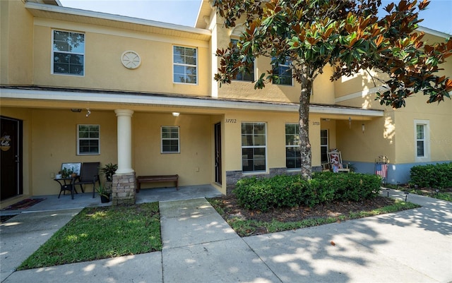 37712 Aaralyn Rd, Zephyrhills, FL 33542 - townhome / multi-family property with stucco siding, stone siding, and a porch