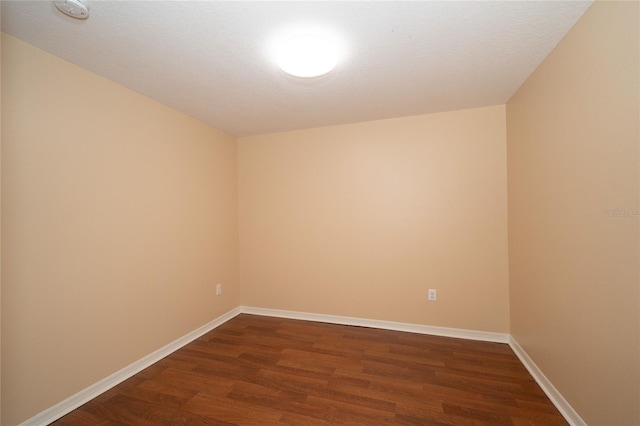 37712 Aaralyn Rd, Zephyrhills, FL 33542 - unfurnished room with dark wood-type flooring, a smoke detector, and baseboards
