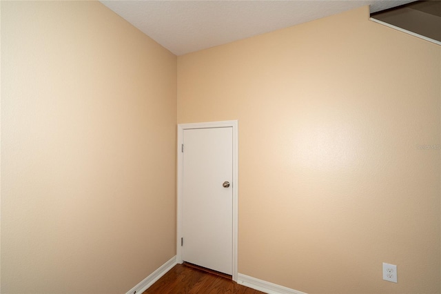 37712 Aaralyn Rd, Zephyrhills, FL 33542 - empty room with baseboards, dark wood-style floors, and lofted ceiling