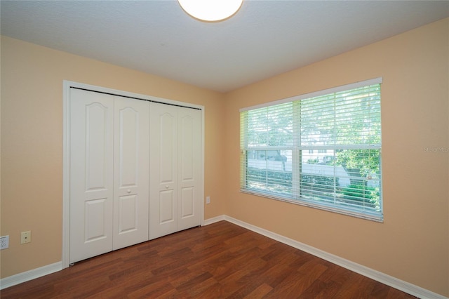 37712 Aaralyn Rd, Zephyrhills, FL 33542 - unfurnished bedroom featuring dark wood finished floors, baseboards, and a closet