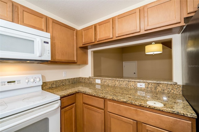 37712 Aaralyn Rd, Zephyrhills, FL 33542 - kitchen featuring white appliances, light stone countertops, and brown cabinets