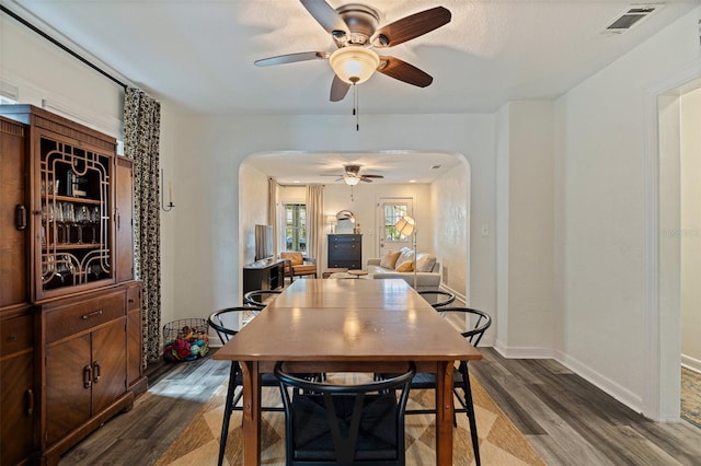 2519 1st Ave N, Saint Petersburg, FL 33713 - dining room featuring arched walkways, ceiling fan, dark wood-style flooring, and baseboards