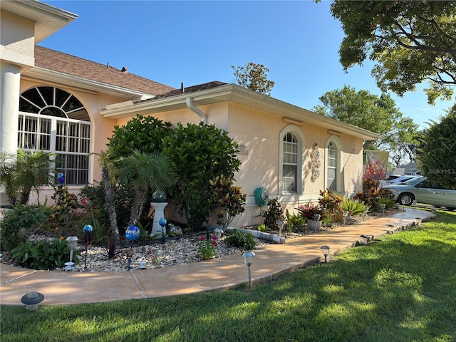 13339 Amberwood St, Hudson, FL 34669 - view of side of property featuring stucco siding and a yard