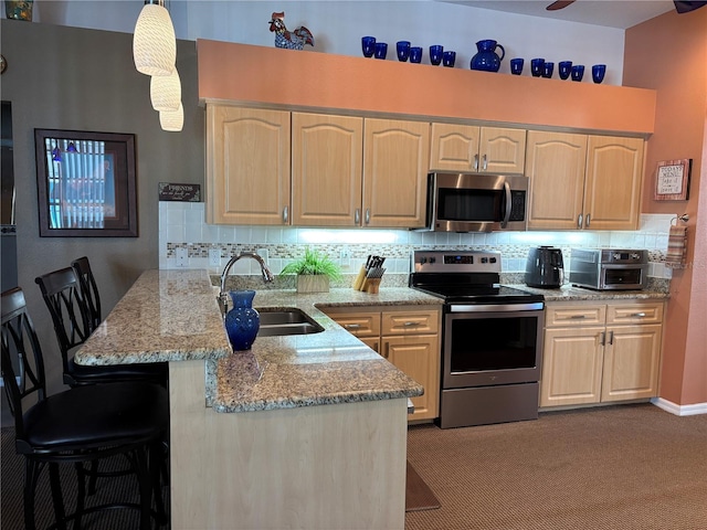 13339 Amberwood St, Hudson, FL 34669 - kitchen featuring appliances with stainless steel finishes, a sink, a peninsula, and light brown cabinets