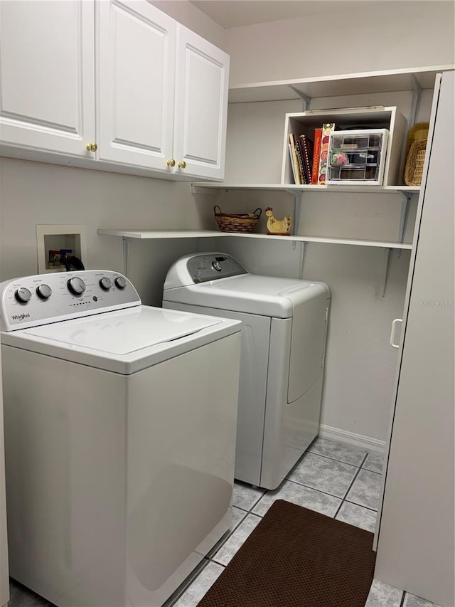 13339 Amberwood St, Hudson, FL 34669 - washroom featuring washing machine and clothes dryer, cabinet space, and light tile patterned flooring