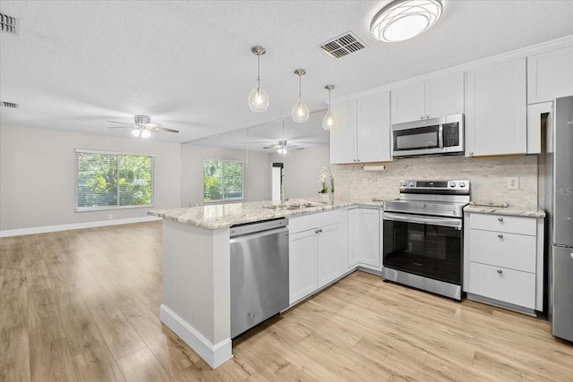 7633 Piping Rock Ct Unit 7633, New Port Richey, FL 34654 - kitchen featuring stainless steel appliances, a ceiling fan, decorative backsplash, open floor plan, and white cabinets