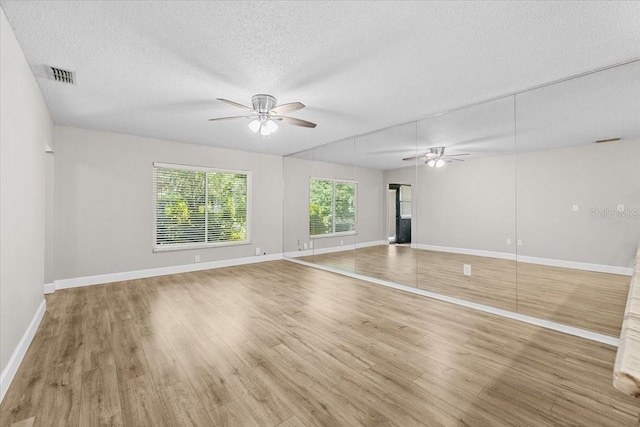 7633 Piping Rock Ct Unit 7633, New Port Richey, FL 34654 - unfurnished living room featuring a ceiling fan, wood finished floors, a textured ceiling, and baseboards