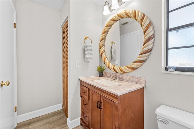 7633 Piping Rock Ct Unit 7633, New Port Richey, FL 34654 - bathroom featuring vanity, toilet, wood finished floors, and baseboards