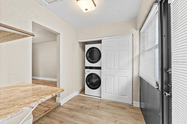 7633 Piping Rock Ct Unit 7633, New Port Richey, FL 34654 - laundry area featuring stacked washer / drying machine, baseboards, light wood-type flooring, and a textured wall