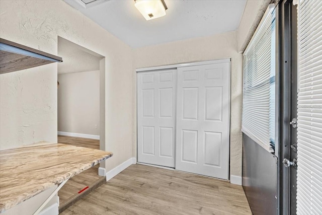 7633 Piping Rock Ct Unit 7633, New Port Richey, FL 34654 - mudroom featuring baseboards, light wood-style floors, and a textured wall