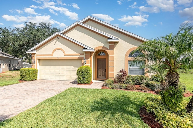 908 Andalusia Loop, Davenport, FL 33837 - view of front facade with stucco siding, a front lawn, driveway, and an attached garage