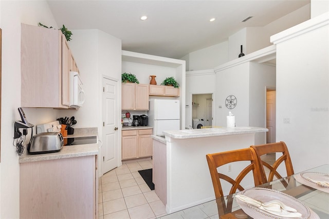 908 Andalusia Loop, Davenport, FL 33837 - kitchen featuring white appliances, light brown cabinets, a breakfast bar area, light countertops, and light tile patterned floors