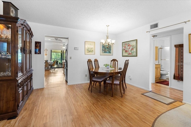 8174 Terrace Garden Dr N Unit 204, Saint Petersburg, FL 33709 - dining room featuring light wood-type flooring, a chandelier, and a textured ceiling