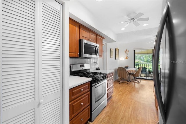 8174 Terrace Garden Dr N Unit 204, Saint Petersburg, FL 33709 - kitchen featuring stainless steel appliances, light wood-style floors, light countertops, brown cabinetry, and ceiling fan