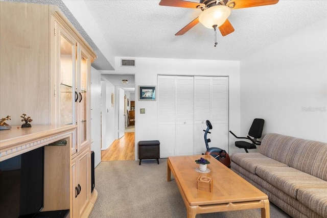 8174 Terrace Garden Dr N Unit 204, Saint Petersburg, FL 33709 - living room featuring a textured ceiling, ceiling fan, and light colored carpet