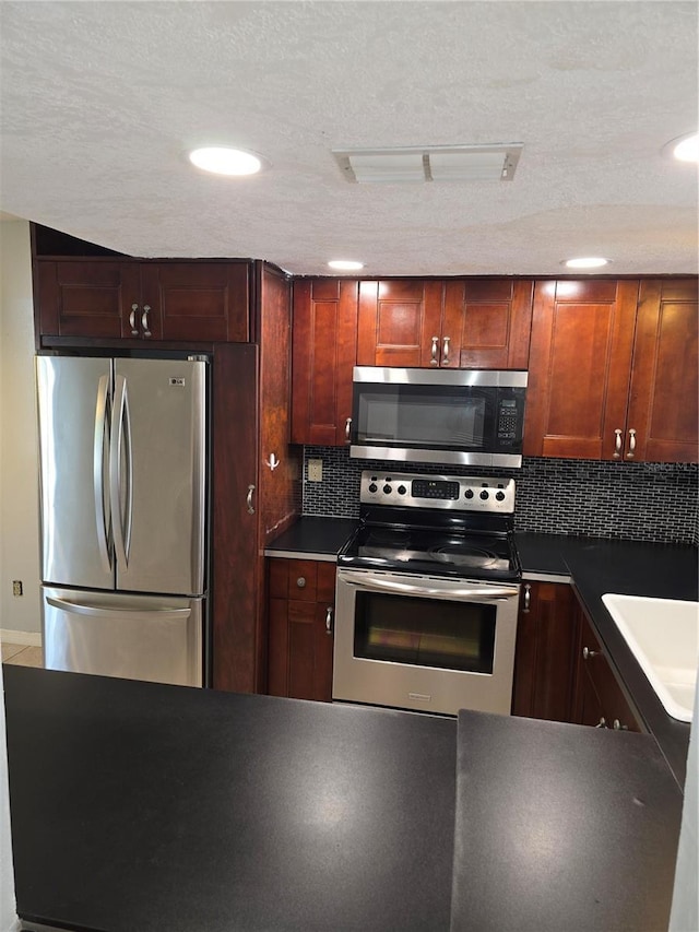 7168 E Bank Dr Unit 7168, Tampa, FL 33617 - kitchen with stainless steel appliances, a sink, tasteful backsplash, dark countertops, and recessed lighting