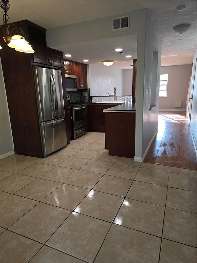 7168 E Bank Dr Unit 7168, Tampa, FL 33617 - kitchen featuring stainless steel appliances, light tile patterned floors, backsplash, baseboards, and dark brown cabinetry