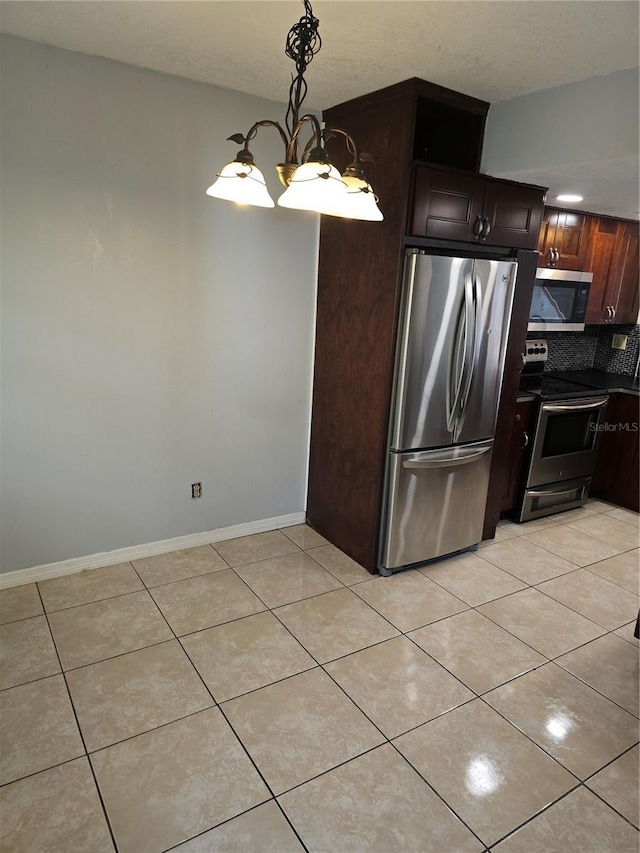 7168 E Bank Dr Unit 7168, Tampa, FL 33617 - kitchen with appliances with stainless steel finishes, light tile patterned floors, tasteful backsplash, decorative light fixtures, and baseboards