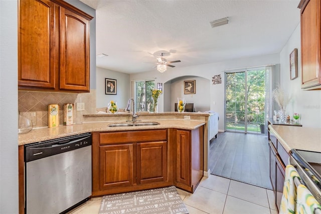 6736 Breezy Palm Dr, Riverview, FL 33578 - kitchen with stainless steel appliances, a sink, a peninsula, arched walkways, and healthy amount of natural light