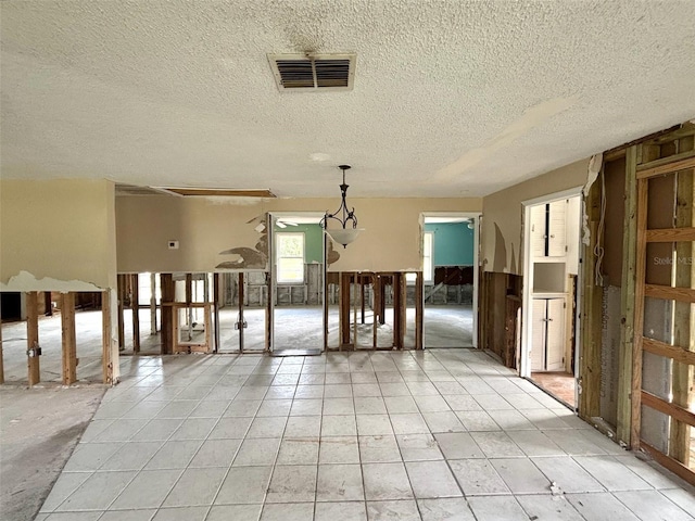 14318 Guava St, Hudson, FL 34667 - empty room featuring a textured ceiling and light tile patterned flooring