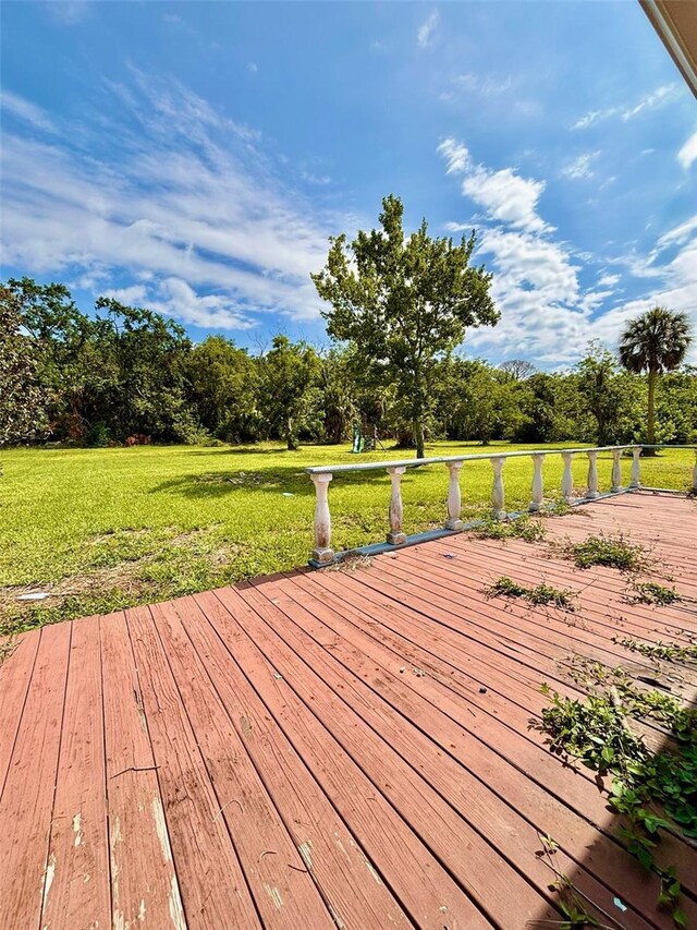 14318 Guava St, Hudson, FL 34667 - wooden deck featuring a lawn and view of scattered trees