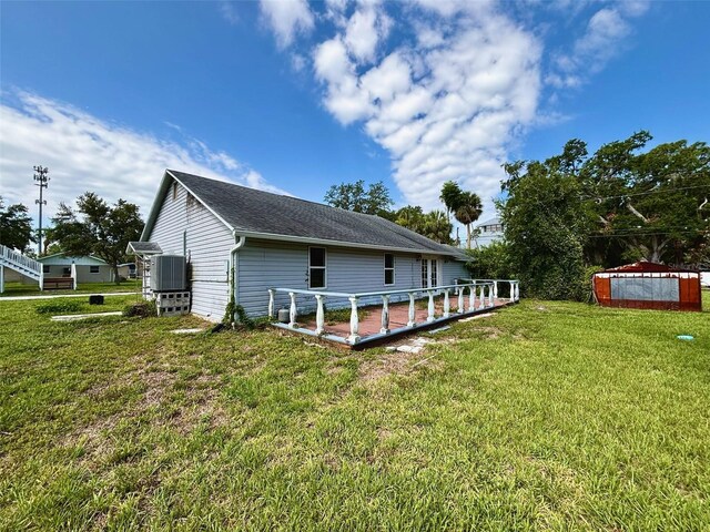 14318 Guava St, Hudson, FL 34667 - back of house featuring a lawn, central AC, and roof with shingles