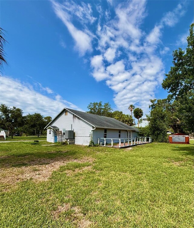 14318 Guava St, Hudson, FL 34667 - view of side of property with central AC unit and a lawn