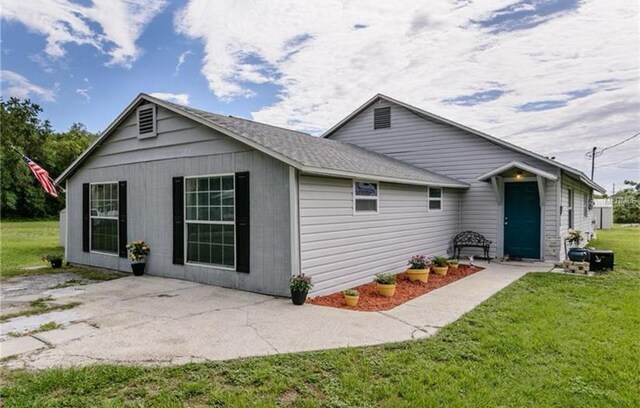 14318 Guava St, Hudson, FL 34667 - rear view of property with a lawn and a patio