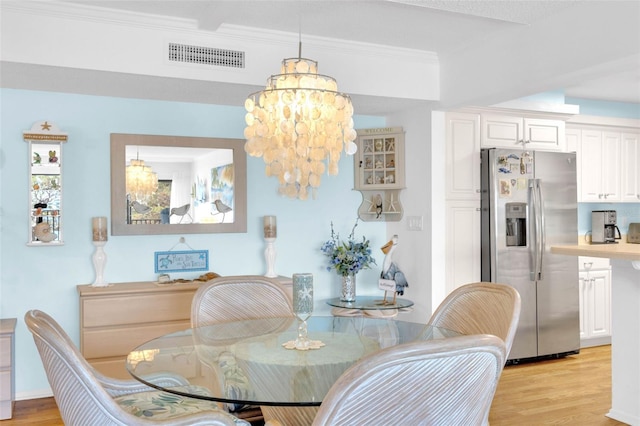 2700 Bayshore Blvd Unit 11308, Dunedin, FL 34698 - dining space featuring light wood finished floors, a chandelier, and crown molding