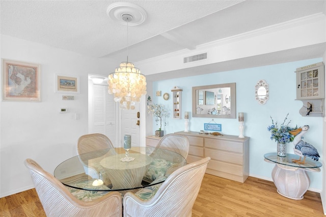 2700 Bayshore Blvd Unit 11308, Dunedin, FL 34698 - dining space featuring a chandelier, light wood finished floors, baseboards, and a textured ceiling