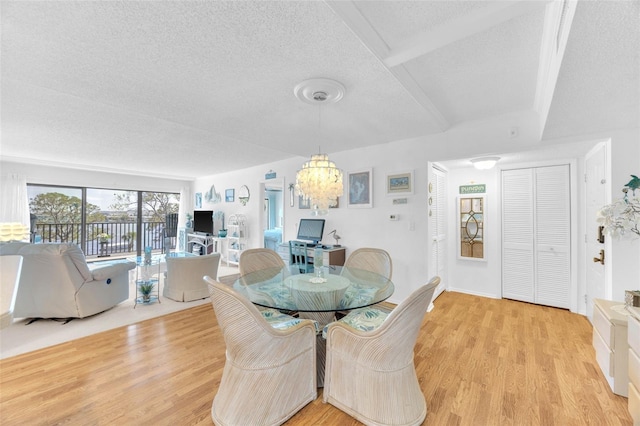 2700 Bayshore Blvd Unit 11308, Dunedin, FL 34698 - dining area with a chandelier, light wood finished floors, and a textured ceiling