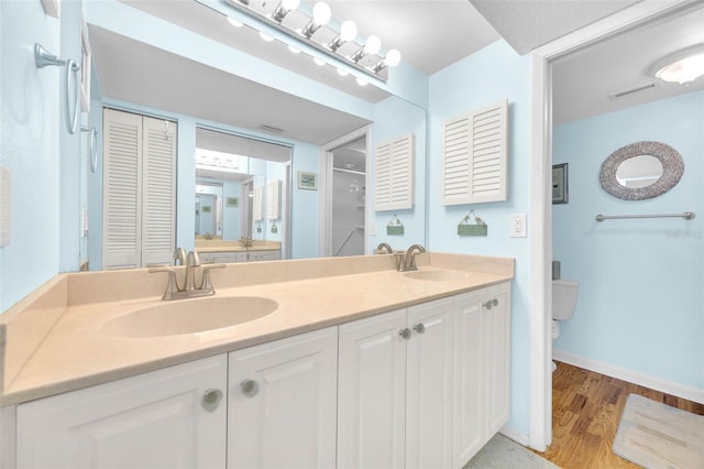 2700 Bayshore Blvd Unit 11308, Dunedin, FL 34698 - full bathroom with toilet, double vanity, a closet, wood finished floors, and baseboards
