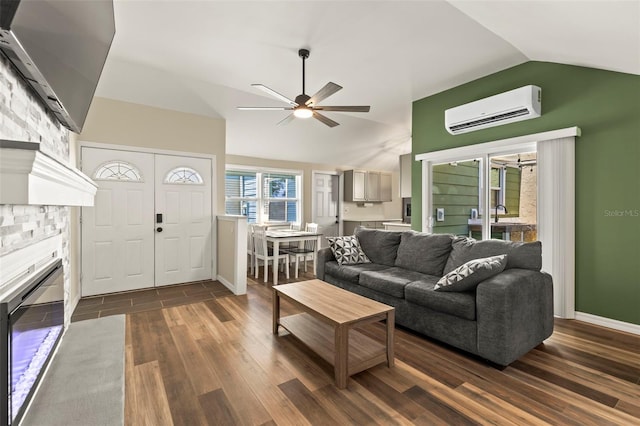 12516 Cobble Stone Dr, Hudson, FL 34667 - living area with a wall mounted air conditioner, vaulted ceiling, dark wood-type flooring, a ceiling fan, and a glass covered fireplace