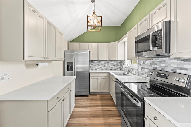 12516 Cobble Stone Dr, Hudson, FL 34667 - kitchen featuring stainless steel appliances, a sink, a chandelier, tasteful backsplash, and pendant lighting