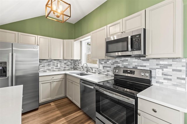 12516 Cobble Stone Dr, Hudson, FL 34667 - kitchen featuring stainless steel appliances, a sink, a chandelier, light countertops, and lofted ceiling
