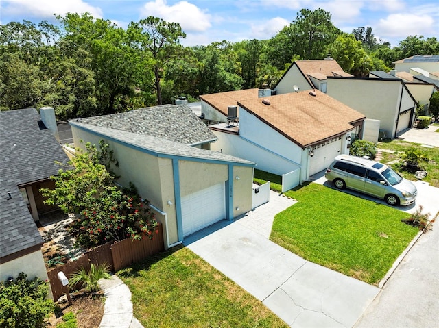 12516 Cobble Stone Dr, Hudson, FL 34667 - view of front of home with concrete driveway, an attached garage, a front lawn, roof with shingles, and stucco siding