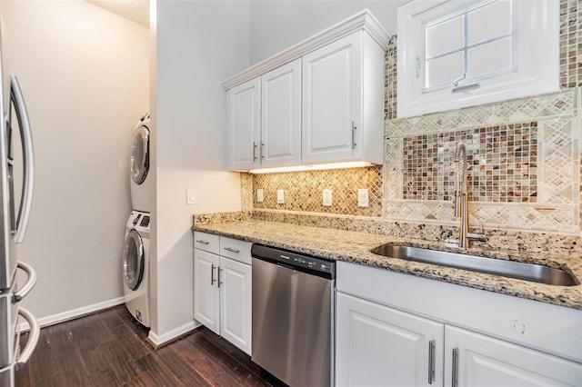 501 Knights Run Ave Unit 6104, Tampa, FL 33602 - kitchen with stainless steel appliances, a sink, stacked washer and clothes dryer, dark wood-type flooring, and decorative backsplash