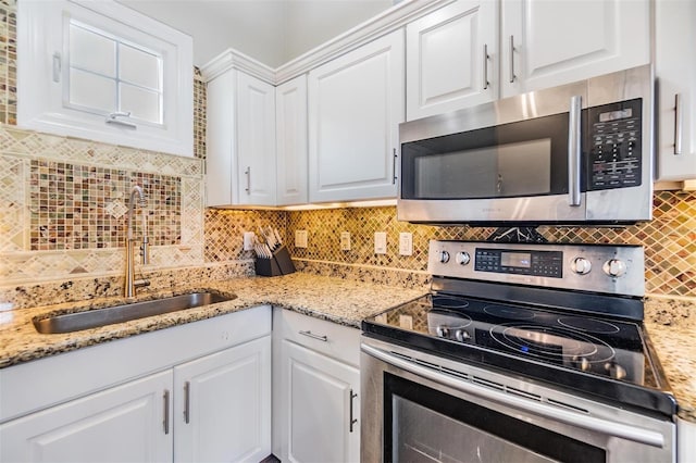 501 Knights Run Ave Unit 6104, Tampa, FL 33602 - kitchen with stainless steel appliances, a sink, white cabinetry, and tasteful backsplash