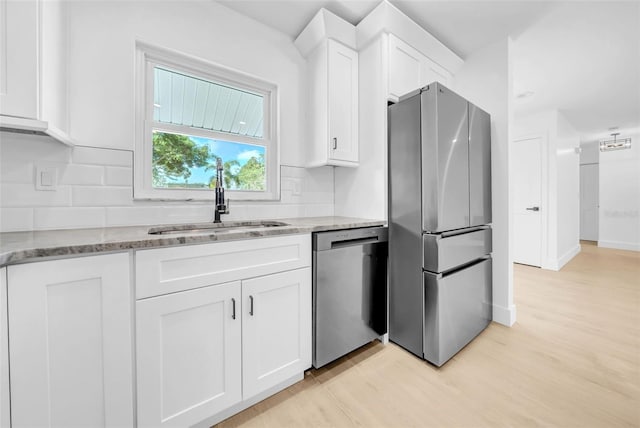 8433 101st Ave, Seminole, FL 33777 - kitchen featuring appliances with stainless steel finishes, a sink, decorative backsplash, white cabinetry, and light stone counters