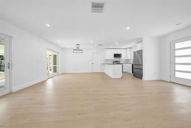 8433 101st Ave, Seminole, FL 33777 - unfurnished living room featuring recessed lighting, light wood-style floors, and baseboards