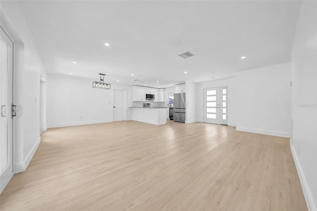 8433 101st Ave, Seminole, FL 33777 - unfurnished living room featuring recessed lighting, light wood-style floors, and baseboards