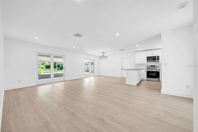 8433 101st Ave, Seminole, FL 33777 - unfurnished living room with recessed lighting, light wood-style floors, and baseboards