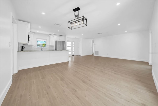 8433 101st Ave, Seminole, FL 33777 - unfurnished living room featuring recessed lighting, light wood-type flooring, and baseboards