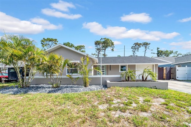 8433 101st Ave, Seminole, FL 33777 - ranch-style house with a fenced front yard, stucco siding, concrete driveway, and a garage