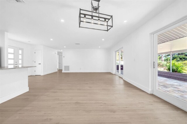 8433 101st Ave, Seminole, FL 33777 - unfurnished living room featuring recessed lighting, light wood-style floors, baseboards, and a chandelier