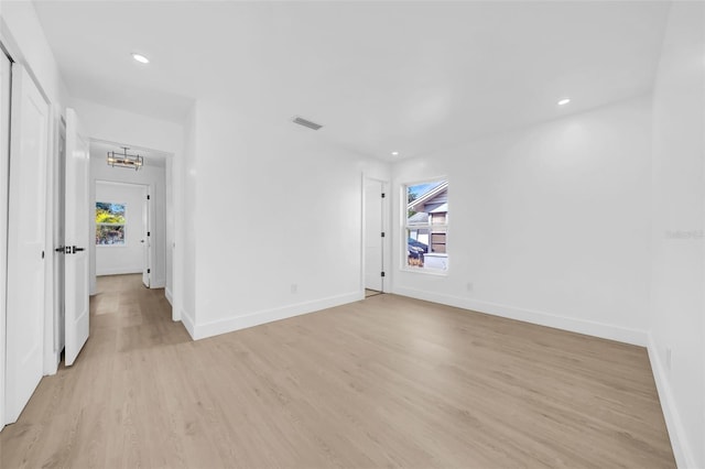 8433 101st Ave, Seminole, FL 33777 - spare room featuring light wood-style flooring, a chandelier, baseboards, and recessed lighting