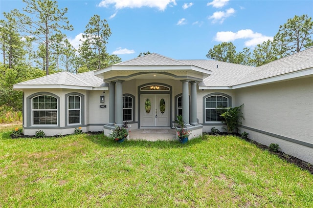 5032 N Crossgate Pt, Beverly Hills, FL 34465 - view of front facade with a front lawn, stucco siding, and a shingled roof