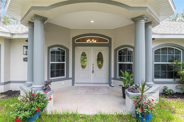 5032 N Crossgate Pt, Beverly Hills, FL 34465 - view of exterior entry with covered porch, stucco siding, and roof with shingles
